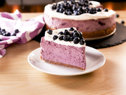 Blueberry cheesecake on a cake stand.