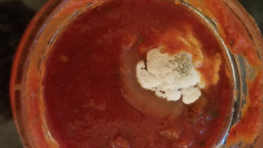 Tomato sauce with mold on it.