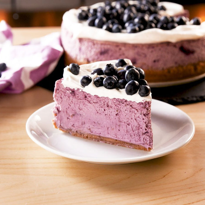 Blueberry cheesecake on a cake stand.