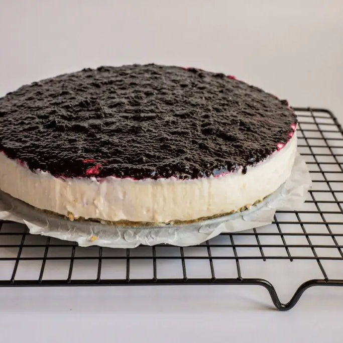 Cheesecake cooling on a baking rack.