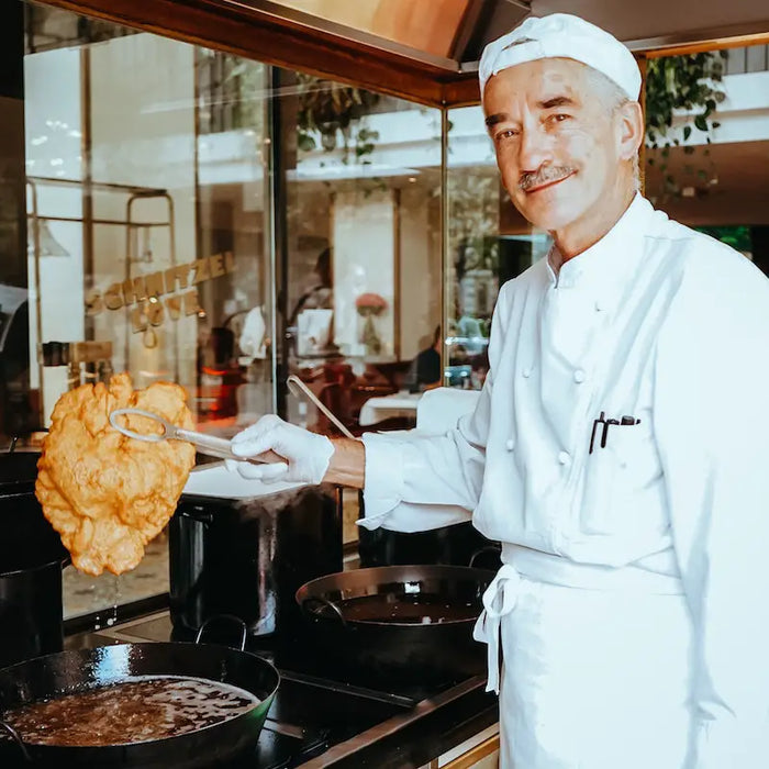 A chef with a fried Schnitzel.