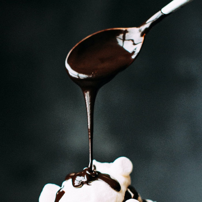 Chocolate syrup poured off a spoon