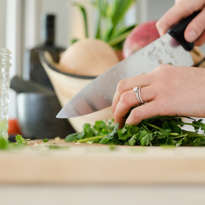 Coarsley chopping vegetables on a chopping board.