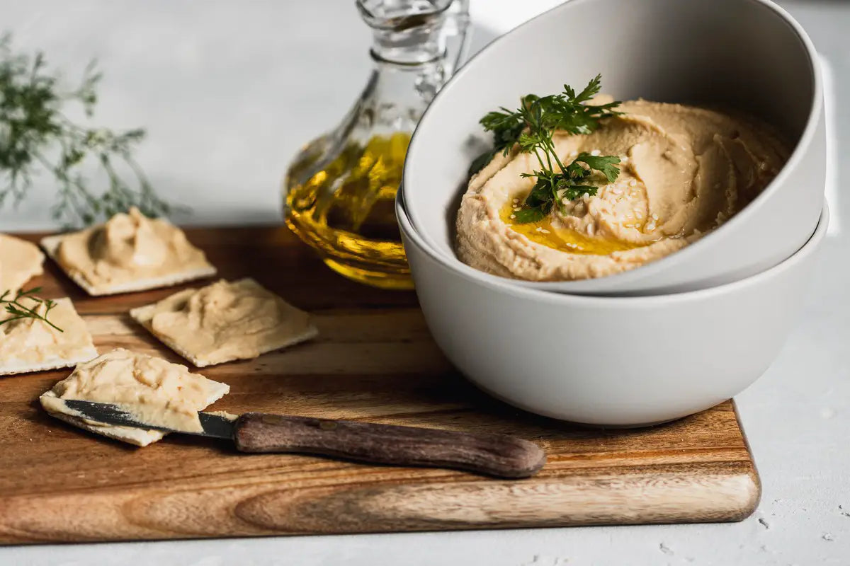 Crackers with hummus on a board.