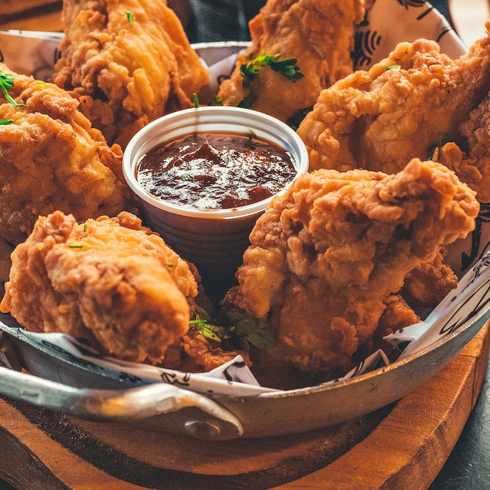 Crispy fried chicken with sauce in a serving bowl.