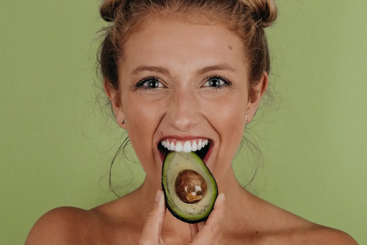 A girl eating an avocado.