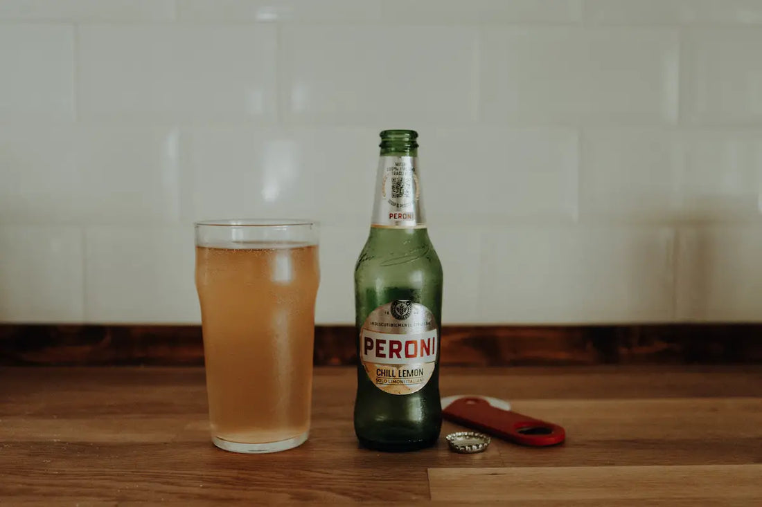 Bottle of peroni and a glass full of beer.