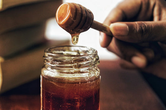 Honey poured into a glass jar.
