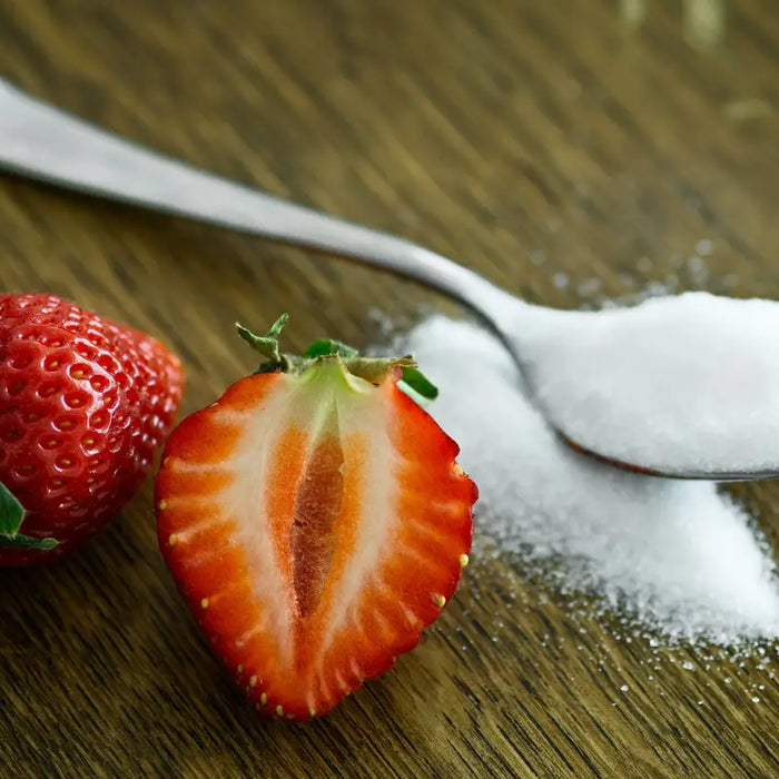 Cut strawberry in half with a spoonful of sugar.