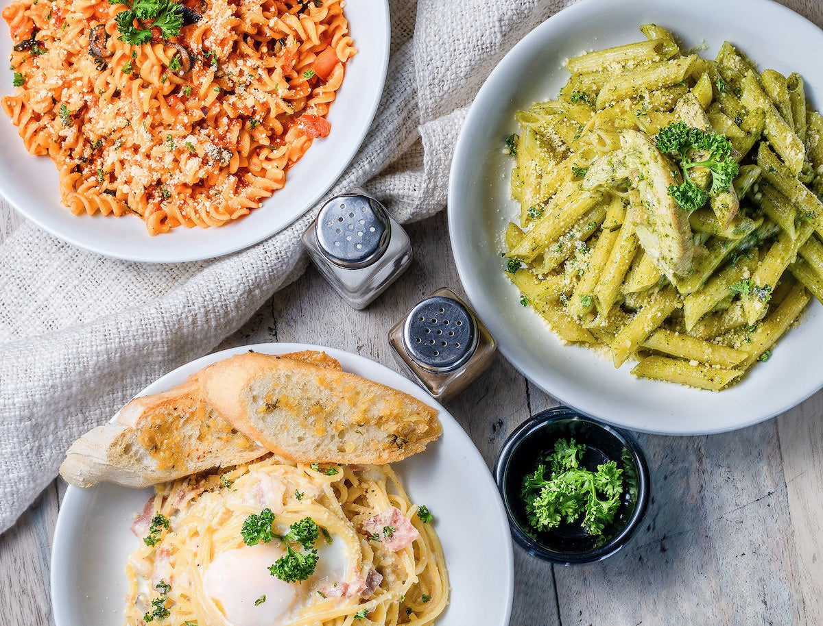 Flatlay of different pasta dishes.