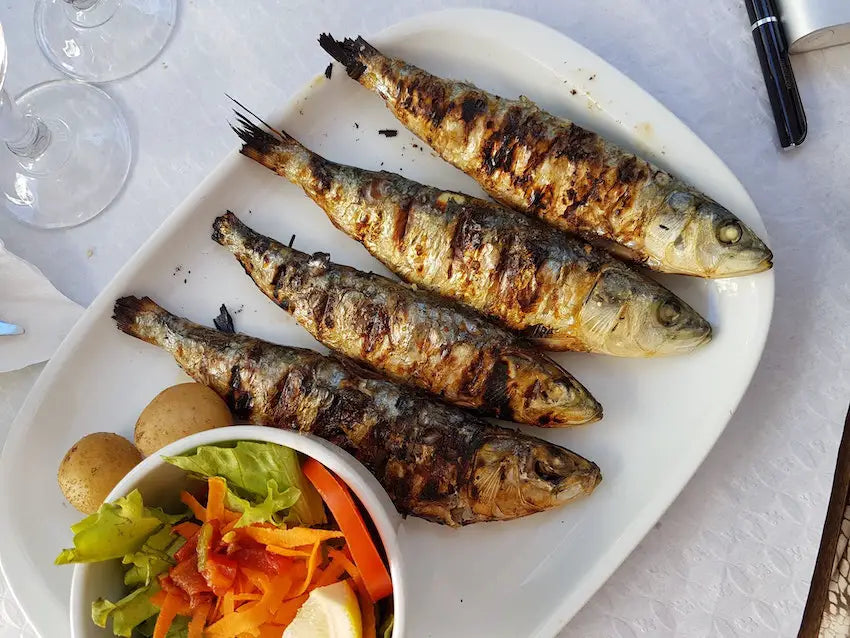 Freshly cooked sardines on a plate.
