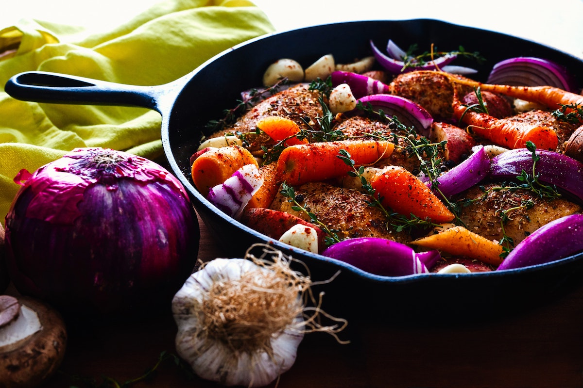 Vegetables frying in a skillet.